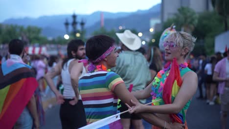 Junge-Moderne-Sexy-Lesbische-Schwule-Homosexuelle-Paare,-Die-Zusammen-Auf-Der-Straße-Mit-Regenbogenfahne-Tanzen