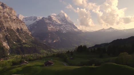 Aerial-drone-footage-dolly-left-to-right-revealing-moody-views-of-picturesque-mountain-village-in-front-of-eiger-north-face-in-swiss-alps