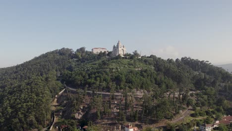 Aerial-Dolly-Vorwärts-In-Richtung-Der-Kirche-Von-Viana-Do-Castelo-In-Portugal-Auf-Einem-Bewaldeten-Hügel