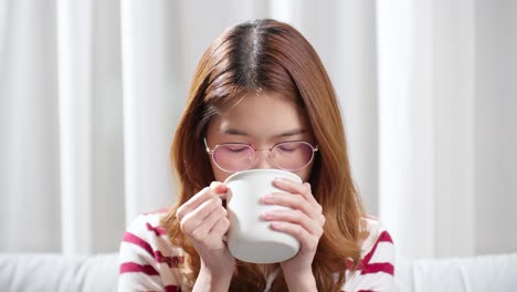 Asiatische-Junge-Frau-An-Einem-Kalten-Tag,-Die-Eine-Heiße-Tasse-Tee-Trinkt,-Um-Sich-Zu-Entspannen
