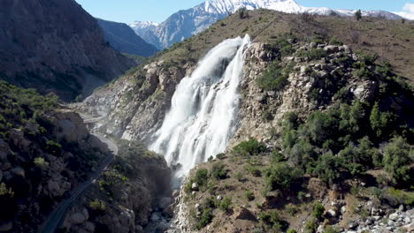 Aerial:-big-waterfall-on-the-mountains-next-to-the-road