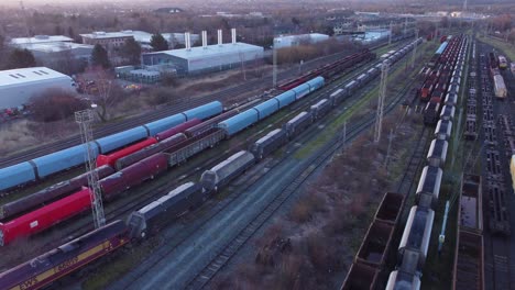 Aerial-view-over-long-train-yard-tracks-and-freight-shipping-tanker-railway-lines-flyover