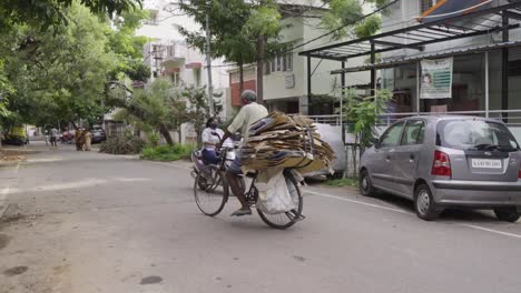 Slow-motion-tracking-shot-of-adult-indian-man-on-bicycle-transporting-rubbish-and-waste-in-Kerala,India