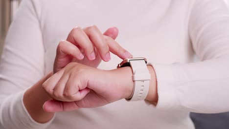Close-up-shot-of-a-woman-hand-who-touch-and-scrolling-on-a-smartwatch-in-order-to-quickly-check-application-connect