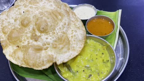 Static-shot-of-delicious-Indian-food-platter-consisting-of-puri,-sabji,-dal-and-chutney