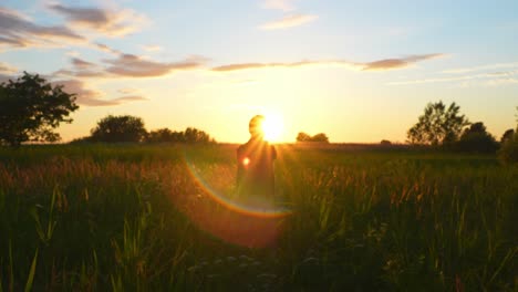 Silhouette-of-man-doing-stretching-exercises-in-middle-of-fields-during-beautiful-golden-hour