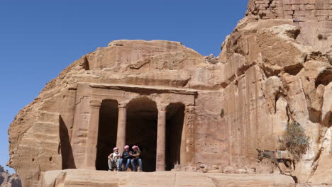 Grupo-De-Turistas-Fuera-De-La-Entrada-Principal-Del-Templo-En-La-Ciudad-De-Petra-Tallada-En-Piedra-De-Roca-En-Jordania-Patrimonio-Mundial-De-La-Unesco