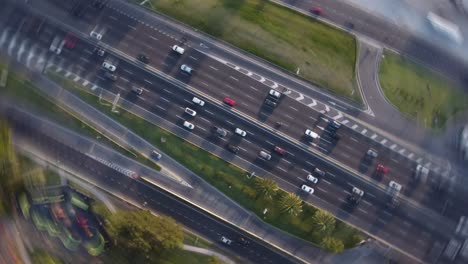 Aerial-circling-shot-showing-many-vehicles-on-highway-in-Buenos-Aires-City-during-sunset--top-down