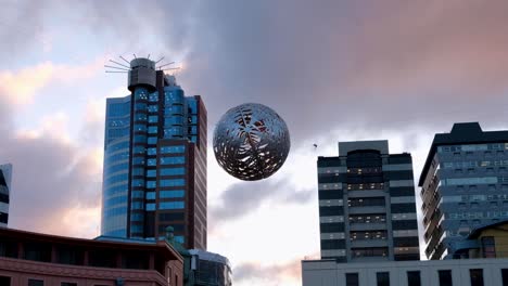 Das-Beliebte-Wahrzeichen-Der-Schwebenden-Farnkugelskulptur-Und-Der-Majestätische-Wolkenkratzer-Im-Zentrum,-Das-Höchste-Gebäude-Der-Stadt,-In-Der-Hauptstadt-Wellington,-Neuseeland,-Aotearoa