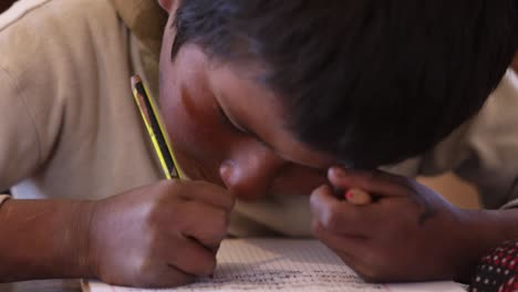Ein-Kleiner-Junge-Schreibt-In-Sein-Notizbuch-In-Einer-Schule-In-Den-Anden-Boliviens