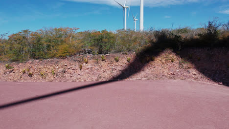 Aerial-truck-shot-of-wind-turbine-shadows-on-desert-ground