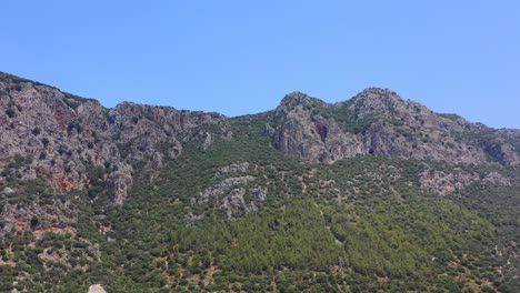 Vista-Aérea-Media-De-Los-Picos-Montañosos-Secos-Y-Escarpados-Cerca-De-Kas-Turquía-En-Un-Día-Soleado-De-Verano
