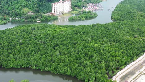 Aerial-dolly-in-reveal-shot-of-riverside-dindings-pantai-desair-apartment-and-kampung-lumut-kiri-fishing-village,-Manjung,-Perak,-Malaysia,-southeast-Asia