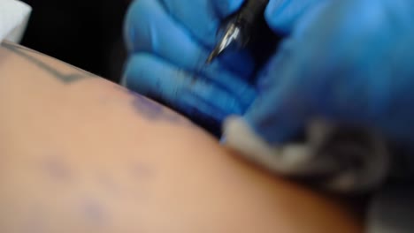 The-tattoo-artist-is-making-a-tattoo-on-a-person's-skin