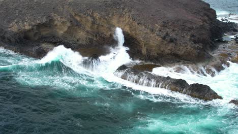 Spray-from-blowhole-with-waves-crashing-around