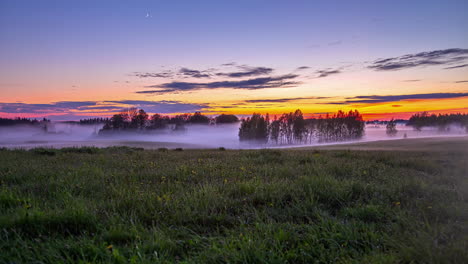 Thin-Foggy-Clouds-Engulfing-Trees-And-Green-Meadows-During-Sunset