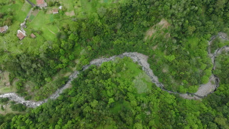 Aerial-overhead-shows-how-ravine-runs-through-verdant-hilly-landscape