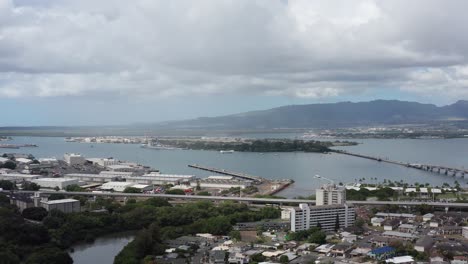 Aerial-wide-dolly-shot-of-Pearl-Harbor-with-the-USS-Arizona-Memorial-in-the-background-on-the-island-of-O'ahu,-Hawaii