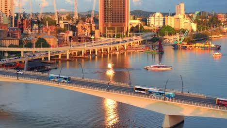 Aerial-View-Of-City-Bus-and-Vehicles-Driving-On-Victoria-Bridge-Over-Brisbane-River-At-Sunset-In-QLD,-Australia