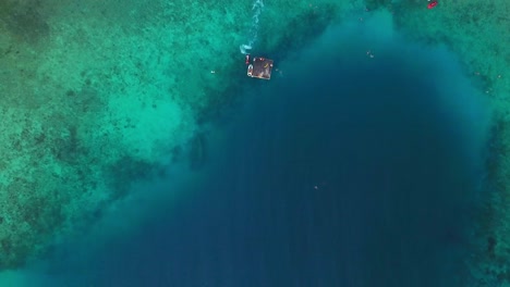 Overhead-boom-down-aerial-view-of-the-pristine-waters-of-Jan-Thiel-Beach,-Curacao,-Dutch-Caribbean-island