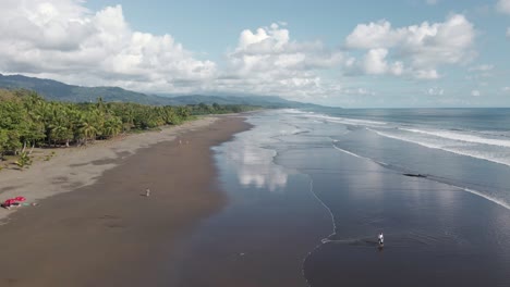 People-playing-in-the-sandy,-shallow-waters-of-Playa-Linda-,-a-hidden-beach-on-the-Central-Pacific-Coast-of-Costa-Rica