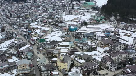 Luftaufnahme-Des-Dorfes-Nozawa-Onsen,-Umgeben-Von-Bergen-In-Nagano,-Japan-Im-Winter
