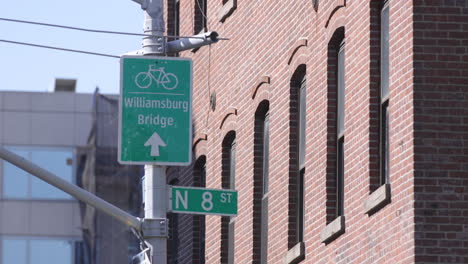 North-8th-Street-Schild-In-Williamsburg,-Brooklyn,-Und-Ein-Pfeil,-Der-Auf-Die-Williamsburg-Brücke-Zeigt