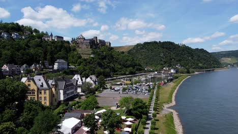 Aerial-flying-drone-shot,-tracking-in,-of-the-Rhine-River-Valley-and-Old-Architecture---including-medieval-castles,-old-buildings,-and-natural-forested-alpine-hills