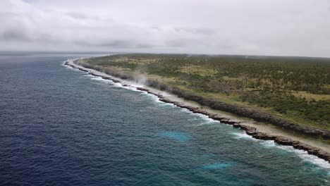Rising-drone-revealing-rugged-coastline-being-battered-with-large-waves-pushing-water-through-blowholes