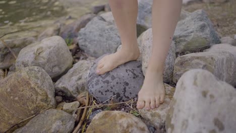 Fußansicht-Eines-Attraktiven-Mädchens,-Das-An-Einem-Felsigen-Strand-Spaziert