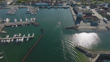 An-aerial-view-of-a-small-fishing-port-with-industrial-buildings,-warehouses,-and-yachts