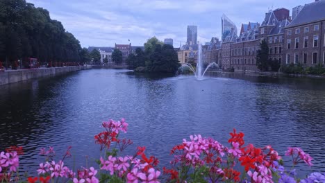 View-at-Buitenhof-of-Hofvijver-with-island-and-The-Hague-Skyline-in-background-in-Dutch-city-Den-Haag-with-beautiful-colored-flowers
