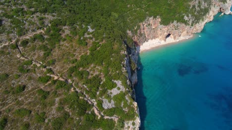 Toma-De-Drone-De-La-Costa-Albanesa-En-El-Mar-Mediterráneo---Drone-Se-Está-Alejando-Dinámicamente-De-Una-Playa-Solitaria