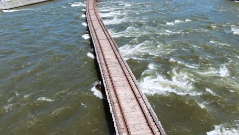 Still-shot-of-train-tracks-across-Fox-River-in-Kaukauna-Wisconsin,-river-raging
