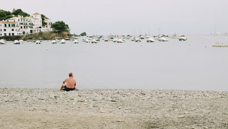 Man-relaxing-on-an-empty-beach