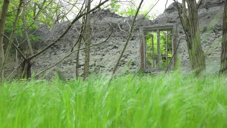 window-of-an-old-abandoned-destroyed-cottage-in-the-woods-camera-moves-slowly-right