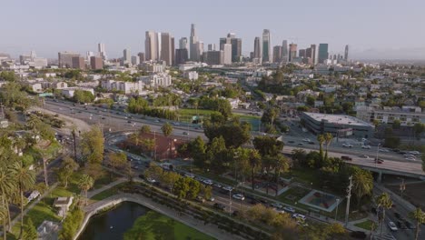 Drohne-Fliegt-An-Einem-Sonnigen-Tag-über-Die-Innenstadt-Von-Los-Angeles,-Echo-Park-Lake-Und-Die-Skyline-Der-Stadt-Im-Blick