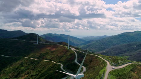 Aerial-flyover-wind-farm-in-rural-mountain-landscape-during-cloudy-day-outdoors-in-nature