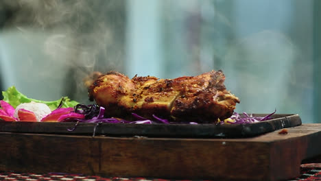 Close-Up-Roasted-Chicken-BBQ-Leg-Piece-on-Round-Table-With-Smoke-in-Beautifull-Background
