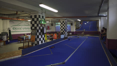 Toy-Cars-Racing-On-The-Floor-In-A-Gaming-Arcade