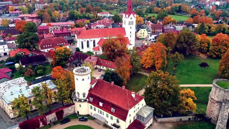 Aerial-drone-shot-over-iconic-medieval-castle-called-Cesis-Castle-in-Latvia-on-a-cloudy-day-with-the-view-of-the-town-in-the-background