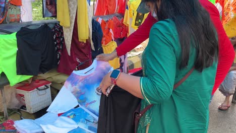 A-lady-shopkeeper-displays-clothes-with-lord-shiva-prints-for-sale-to-pilgrims
