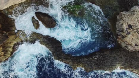 An-aerial-shot-of-waves-crashing-on-rocks