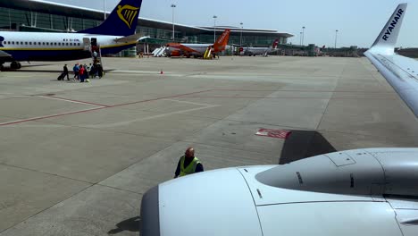 Ein-Flughafentechniker-Geht-Auf-Dem-Rollfeld-Des-Flughafens-Porto,-Portugal,-In-Die-Nähe-Eines-Flugzeugtriebwerks