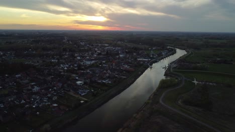 River-Scheldt-and-Serskamp-Village,-Belgium-on-Sunset,-Aerial-View