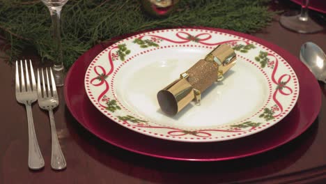 Closeup-Pan-decorated-Christmas-dinner-plate-setting-wooden-table