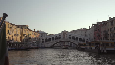 Wide-shot-of-Italian-flag-and-Ponte-di-Rialto-bridge-at-morning-with-no-people,-Venice,-Italy