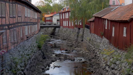 Ein-Ausgetrockneter-Steinkanal-Zwischen-Alten-Roten-Häusern