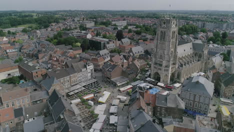 AERIAL:-A-market-on-a-church-square-in-the-centre-of-the-city-with-a-view-on-the-city's-basilica