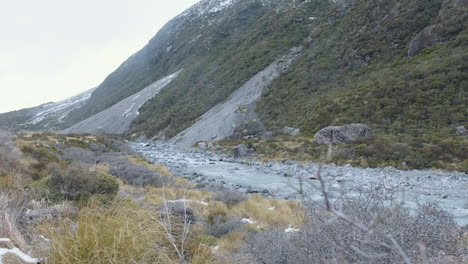 Un-Lago-Glacial-Rocoso-Y-Corriendo-Entre-Montañas-Nevadas-En-Medio-Del-Invierno-En-Nueva-Zelanda